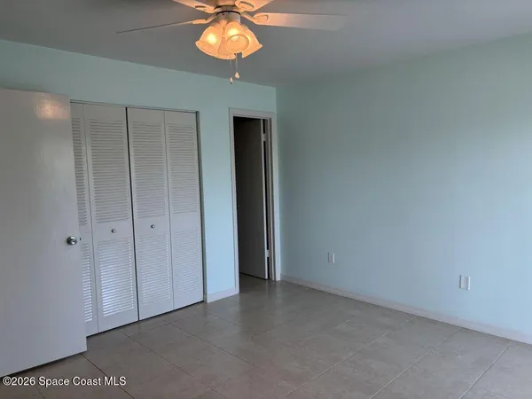 an empty room with a chandelier fan