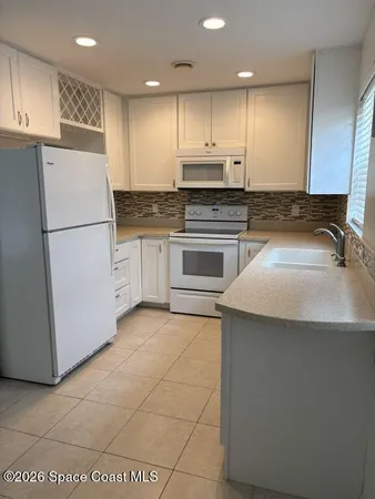 a kitchen with a refrigerator sink and cabinets