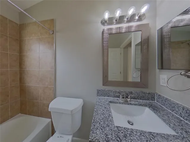 a bathroom with a sink a toilet a mirror and bathtub