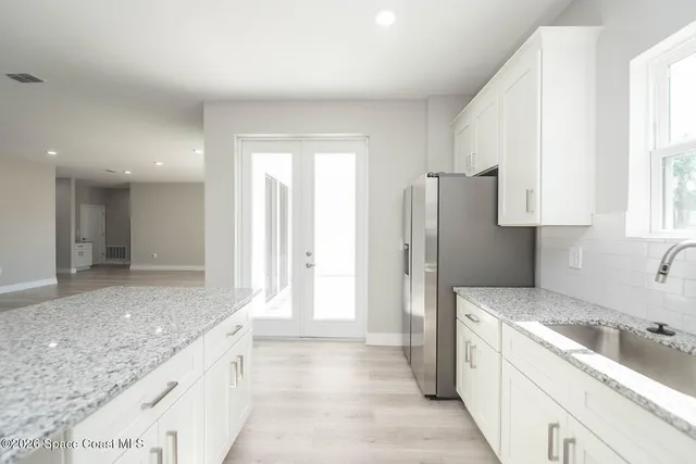 a kitchen with granite countertop a refrigerator and a sink