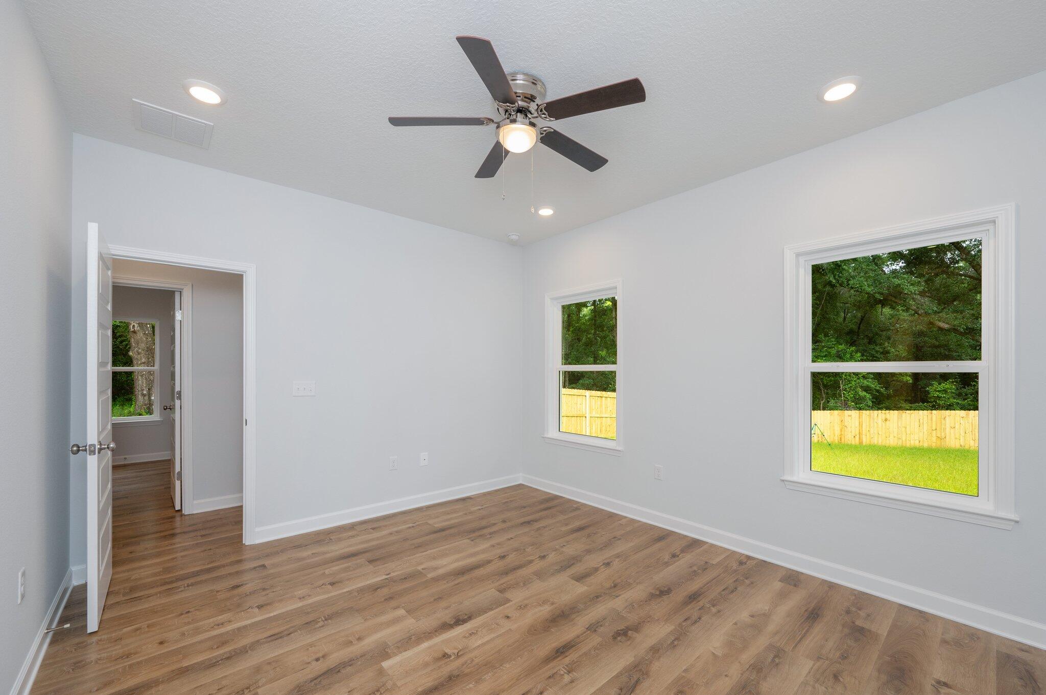 585 Brock Avenue Crestview, FL 32539 - Photo 22 of 29 a view of an empty room with a window and wooden floor
