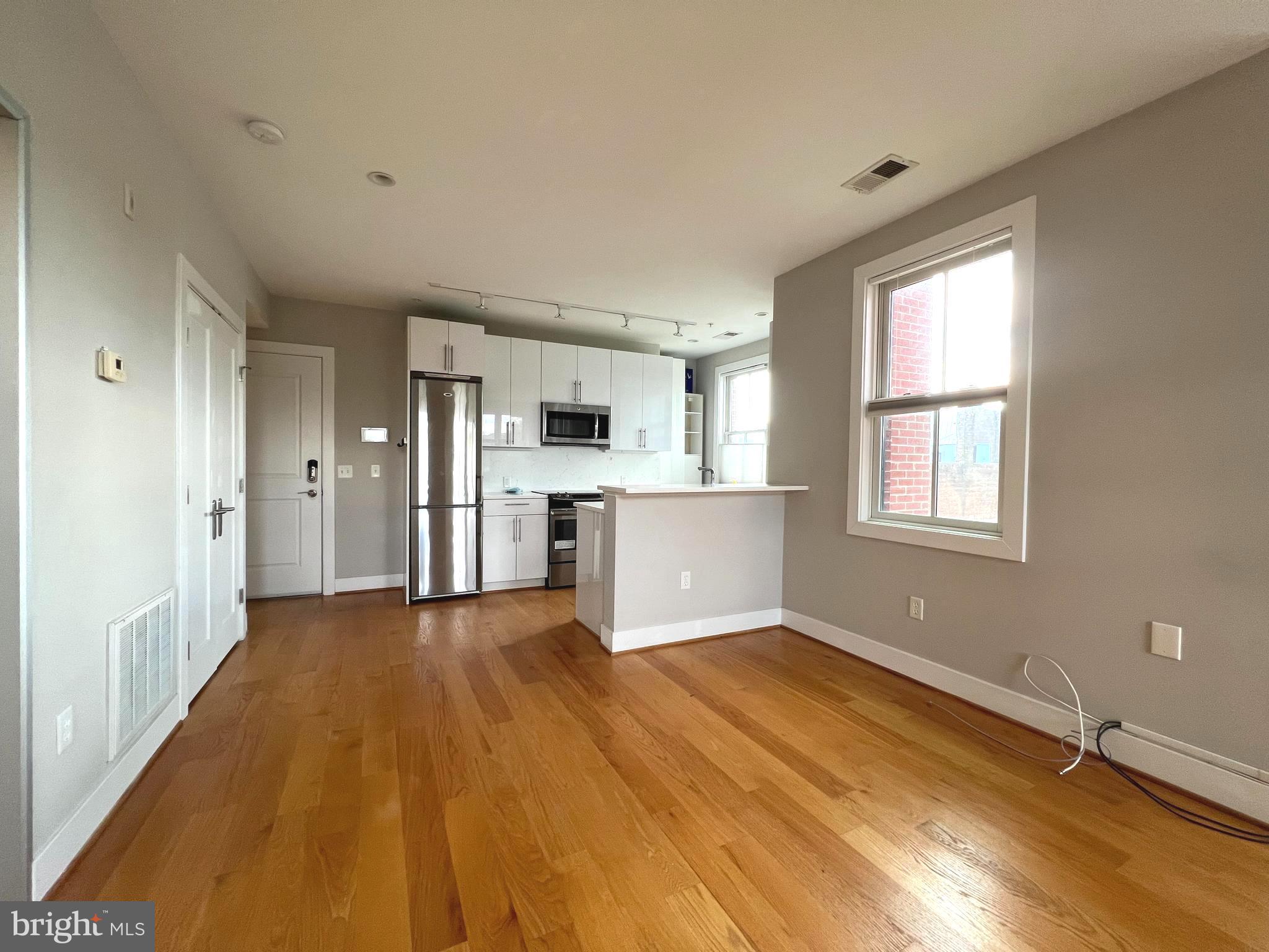 1209 G Street Southeast, Unit 8 Washington, DC 20003 - Photo 3 of 27 a view of an empty room with window and wooden floor