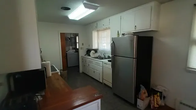a kitchen with a refrigerator a sink and cabinets