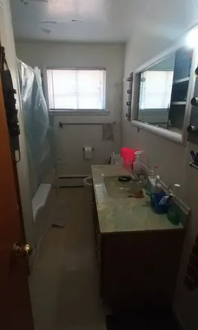a bathroom with a sink toilet next to a window