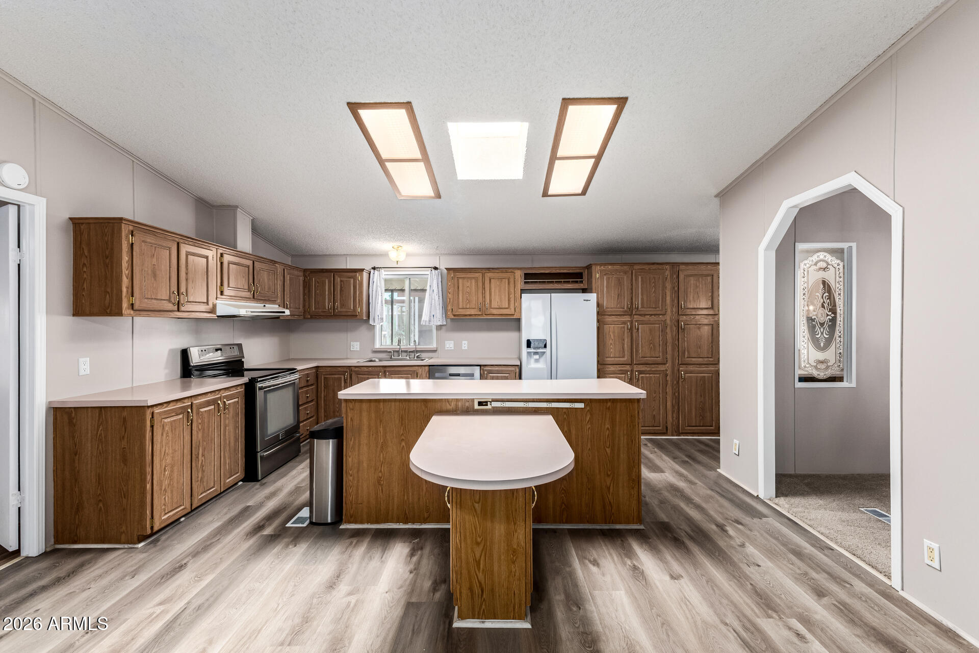 3330 East Main Street, Unit 446 Mesa, AZ 85213 - Photo 11 of 29 a kitchen with kitchen island a sink table and chairs
