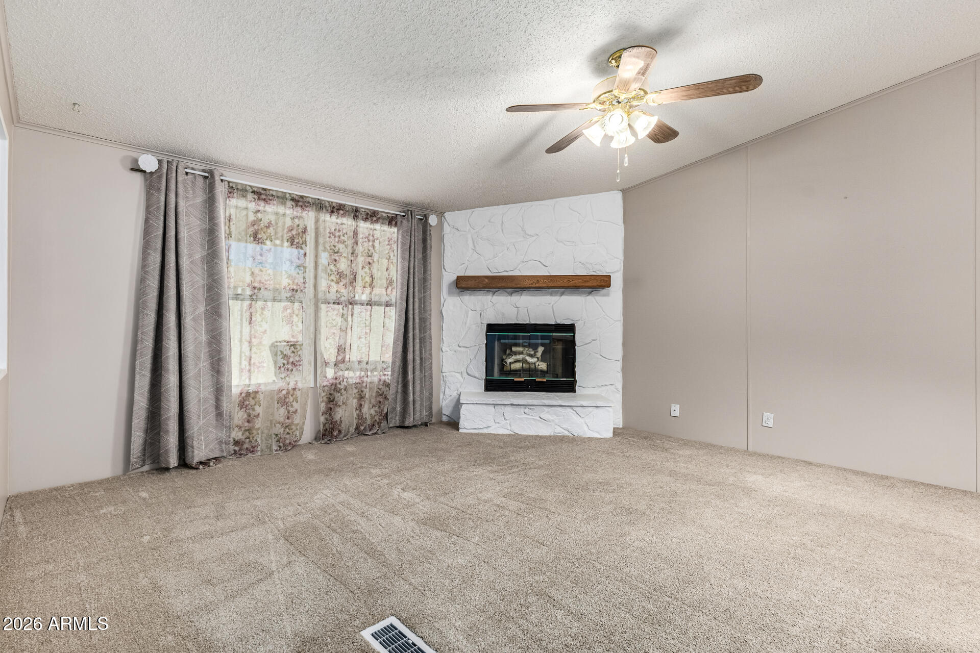 3330 East Main Street, Unit 446 Mesa, AZ 85213 - Photo 6 of 29 a view of an empty room with a fireplace and a window