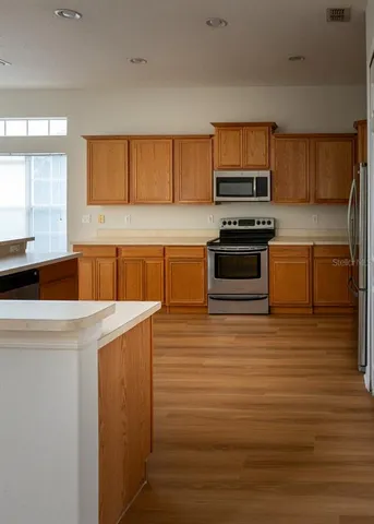 a kitchen with stainless steel appliances a stove sink microwave and cabinets