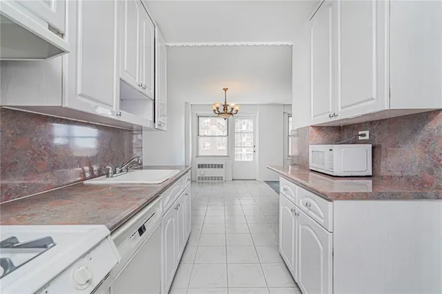a kitchen with granite countertop a sink dishwasher stove and cabinets