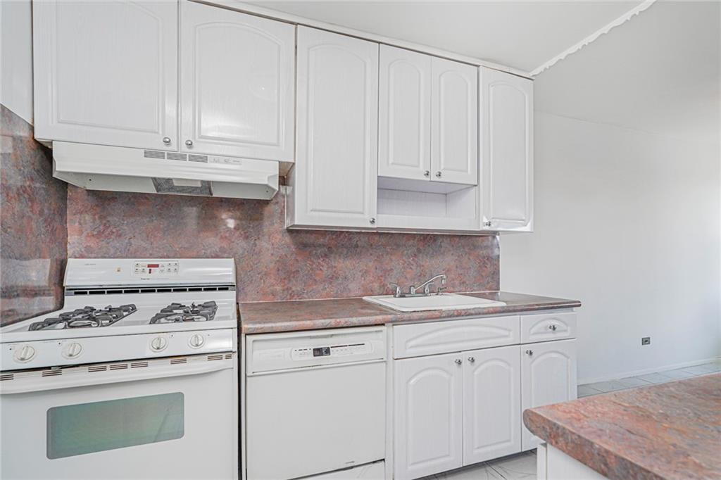 1935 Shore Parkway, Unit 9F Brooklyn, NY 11214 - Photo 12 of 20 a kitchen with granite countertop white cabinets and white appliances