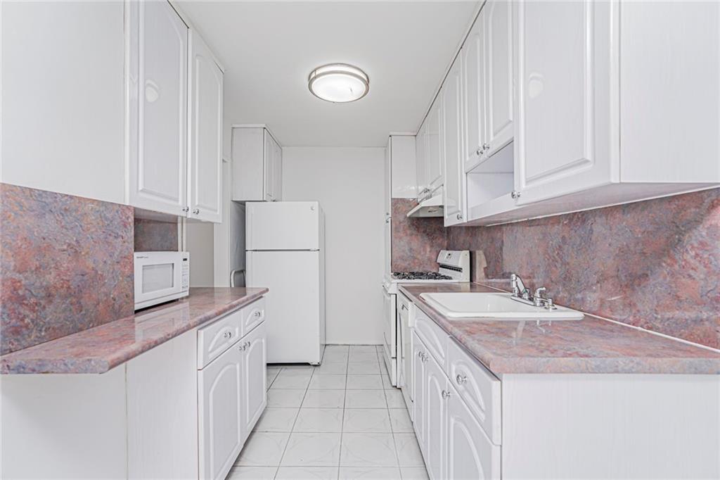 1935 Shore Parkway, Unit 9F Brooklyn, NY 11214 - Photo 9 of 20 a kitchen that has a sink and a stove