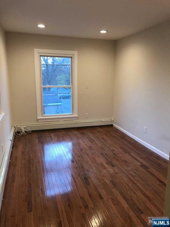 282 South Broad Street, Unit 2 FRONT DOOR Ridgewood, NJ 07450 - Photo 4 of 13 an empty room with wooden floor and windows