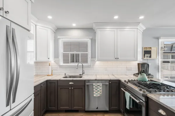 a kitchen with granite countertop a sink stove and refrigerator