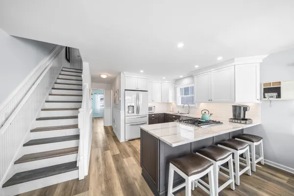 a kitchen with a dining table chairs and white cabinets