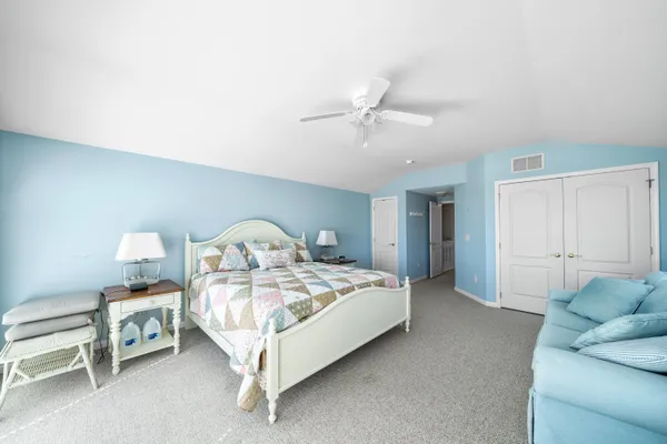 a spacious bedroom with a bed and a chandelier