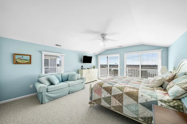 a spacious bedroom with a bed couch and window