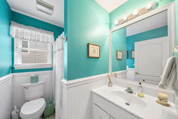 a bathroom with a sink vanity mirror and toilet