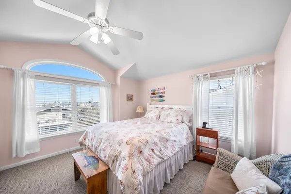 a bedroom with a large bed and a chandelier fan