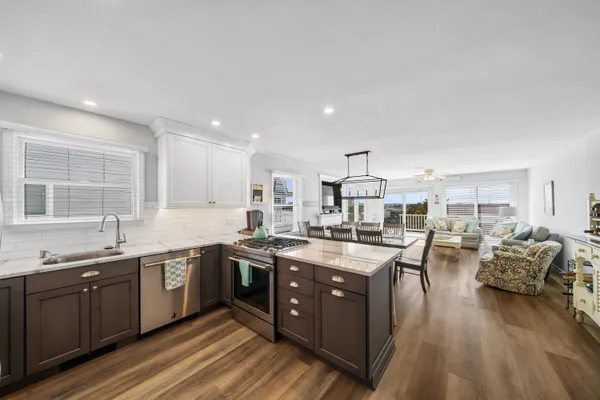 a large kitchen with lots of counter space a sink and stainless steel appliances