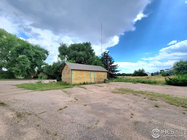 a view of a house with backyard and trees