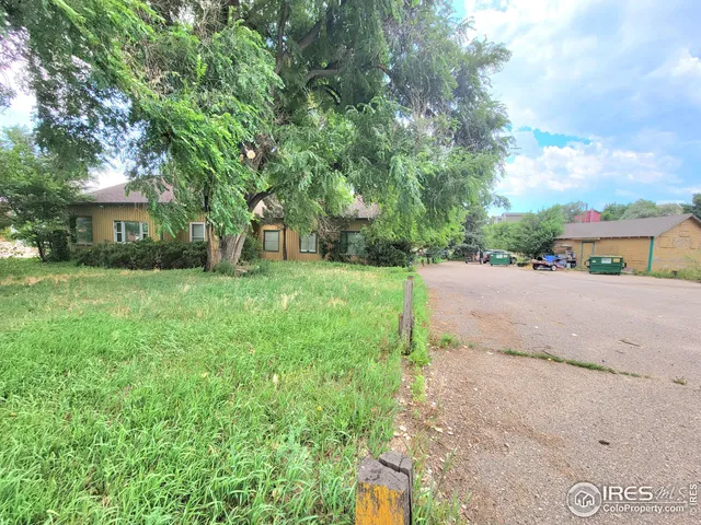 a view of a street with a house in the background