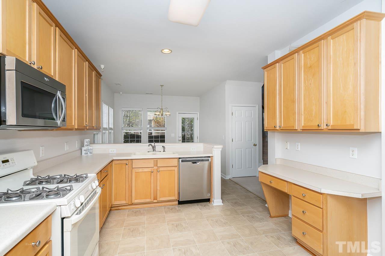 7468 Silver View Lane Raleigh, NC 27613 - Photo 4 of 31 a large kitchen with stainless steel appliances granite countertop a stove a sink and a microwave