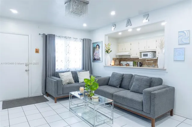 a living room with furniture and kitchen view