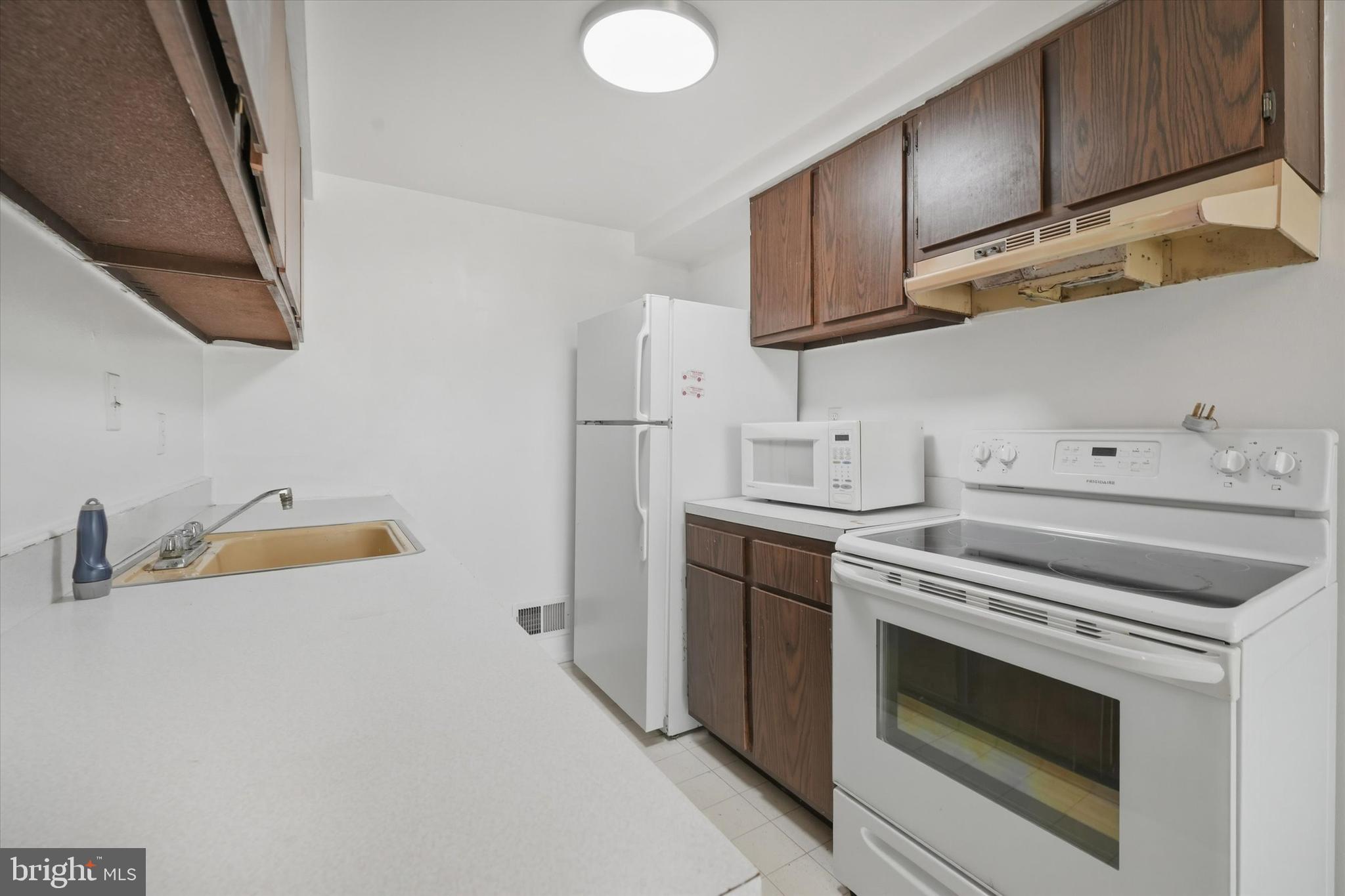 125 Elliot Street Newark, DE 19713 - Photo 13 of 32 a kitchen with granite countertop a sink a stove and cabinets