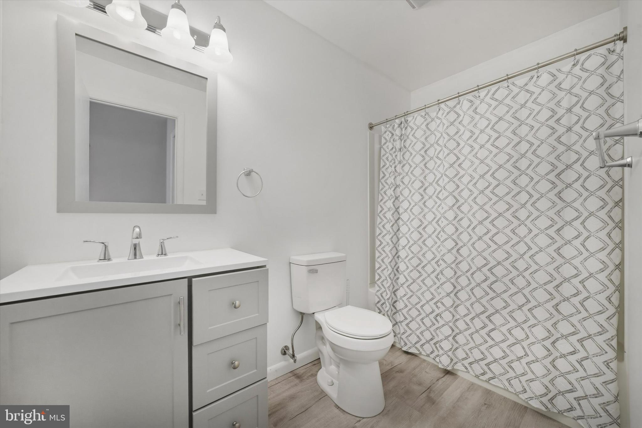 125 Elliot Street Newark, DE 19713 - Photo 18 of 32 a bathroom with a toilet sink vanity and mirror