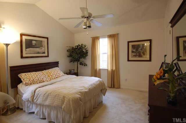 4513 Timberhurst Drive Raleigh, NC 27612 - Photo 7 of 10 a bedroom with a bed and a chandelier