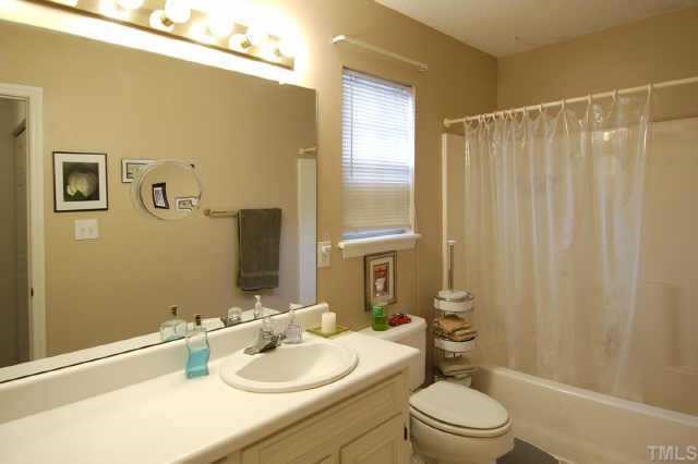 4513 Timberhurst Drive Raleigh, NC 27612 - Photo 8 of 10 a bathroom with a sink a toilet and shower curtain