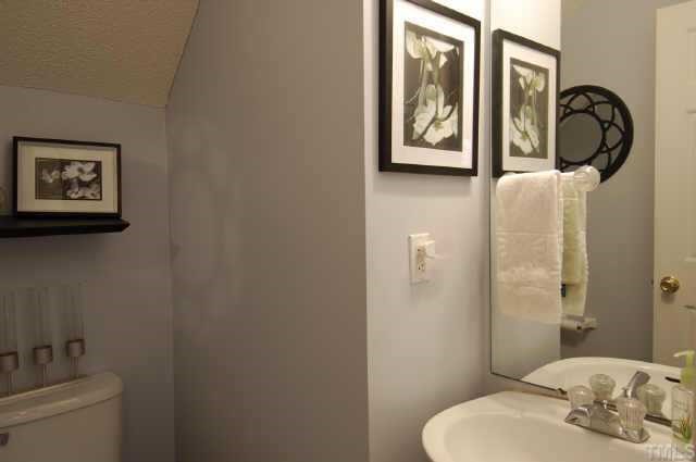 4513 Timberhurst Drive Raleigh, NC 27612 - Photo 9 of 10 a bathroom with a toilet a sink and mirror