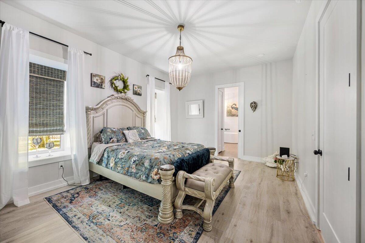 3574 Bob Tolbert Road Navarre, FL 32566 - Photo 26 of 67 a bedroom with a bed and wooden floor