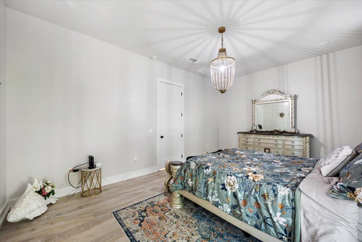 3574 Bob Tolbert Road Navarre, FL 32566 - Photo 27 of 67 a bedroom with a bed and wooden floor