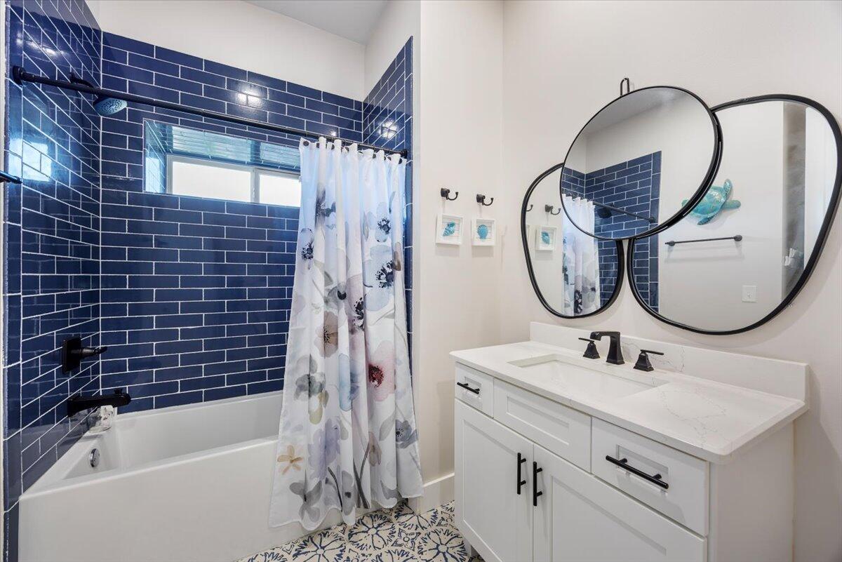 3574 Bob Tolbert Road Navarre, FL 32566 - Photo 37 of 67 a bathroom with a sink a mirror a bathtub and a shower