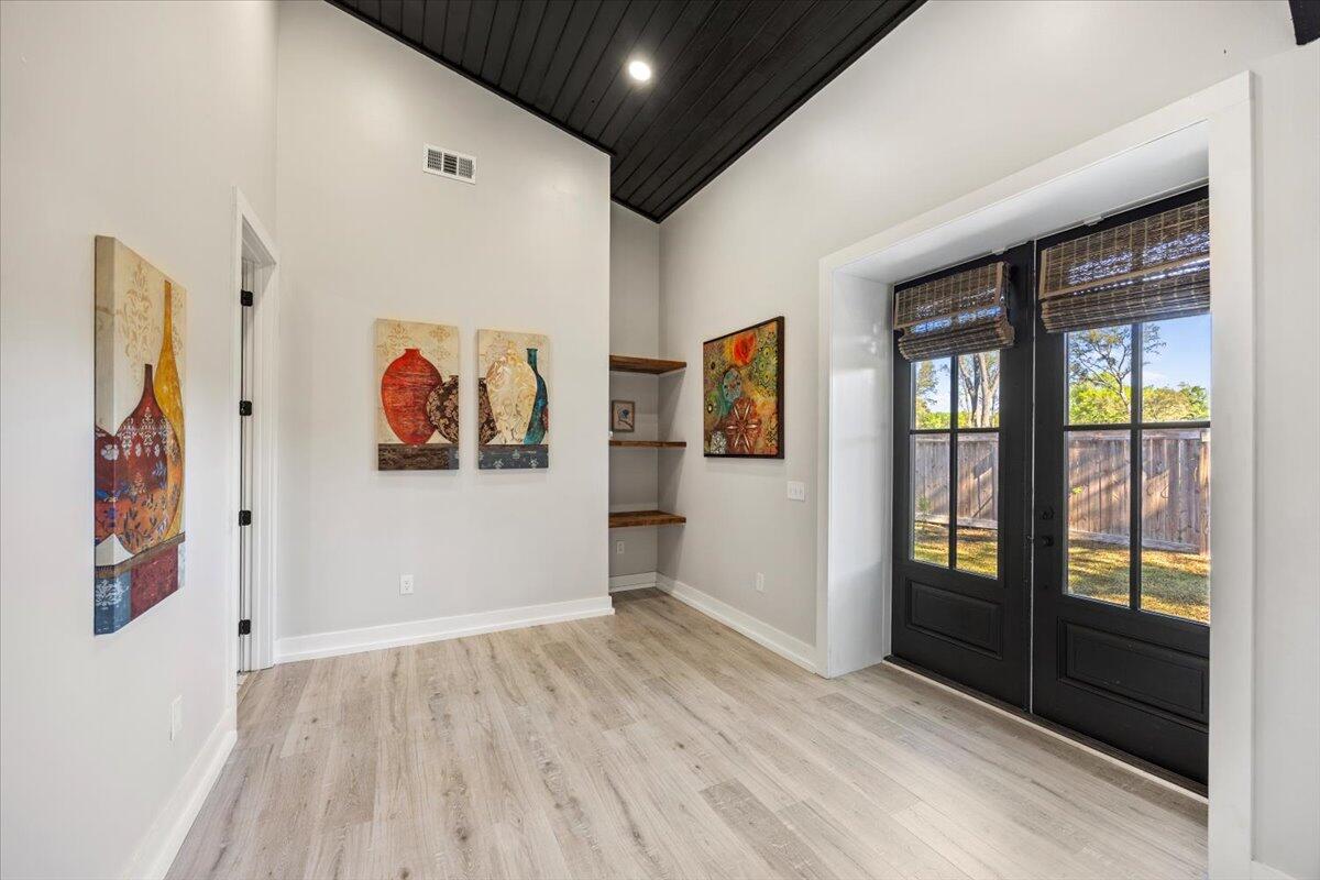 3574 Bob Tolbert Road Navarre, FL 32566 - Photo 42 of 67 a view of a hallway with wooden floor and windows