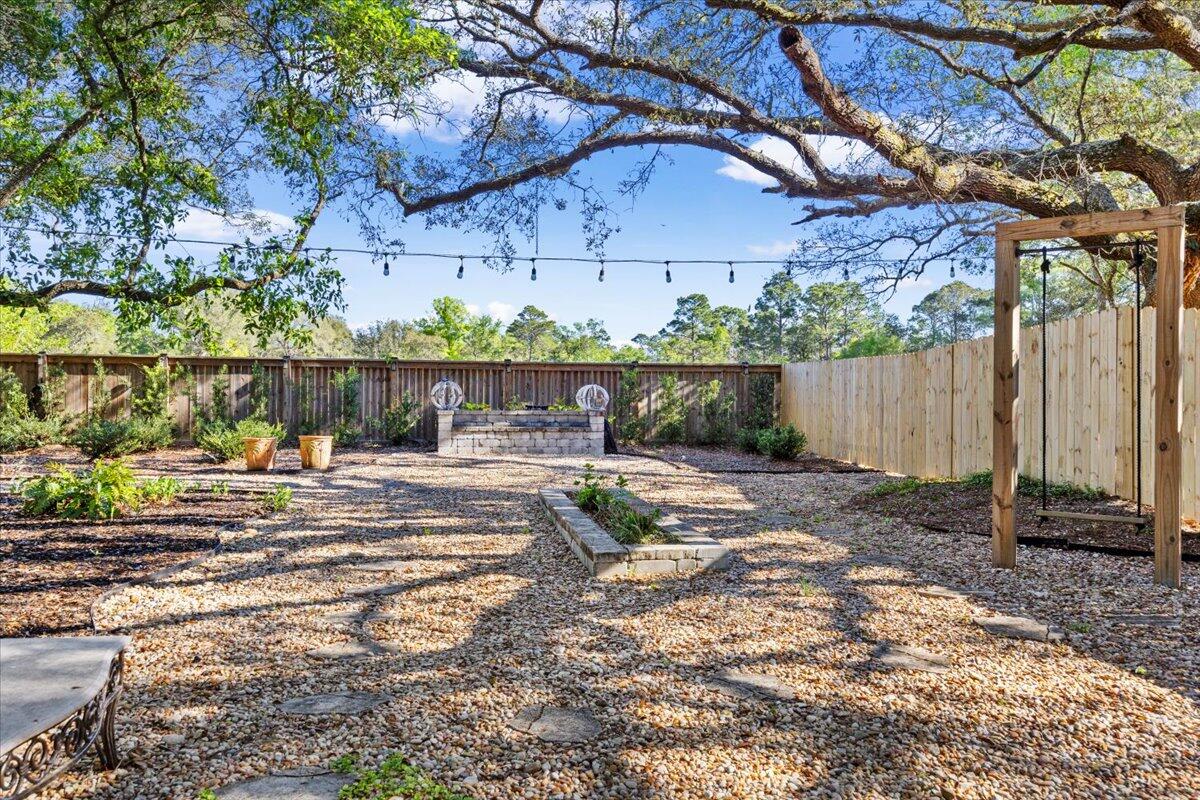 3574 Bob Tolbert Road Navarre, FL 32566 - Photo 59 of 67 a view of a yard with plants and a table under an umbrella
