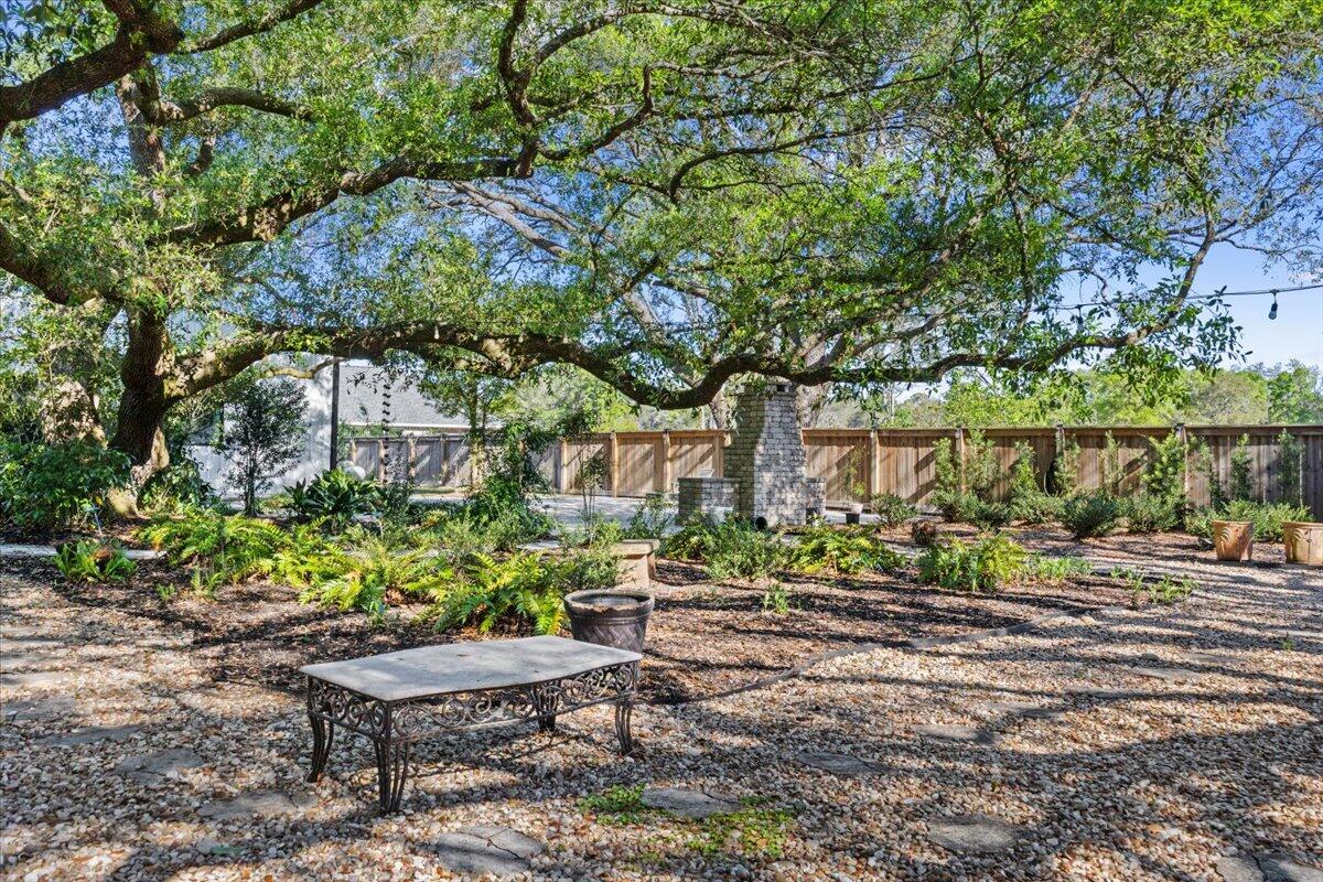 3574 Bob Tolbert Road Navarre, FL 32566 - Photo 65 of 67 a garden with a table and chairs and potted plants
