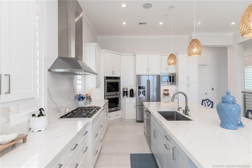 4824 Watersong Way Fort Pierce, FL 34949 - Photo 20 of 65 a kitchen with stainless steel appliances kitchen island granite countertop a sink and a refrigerator