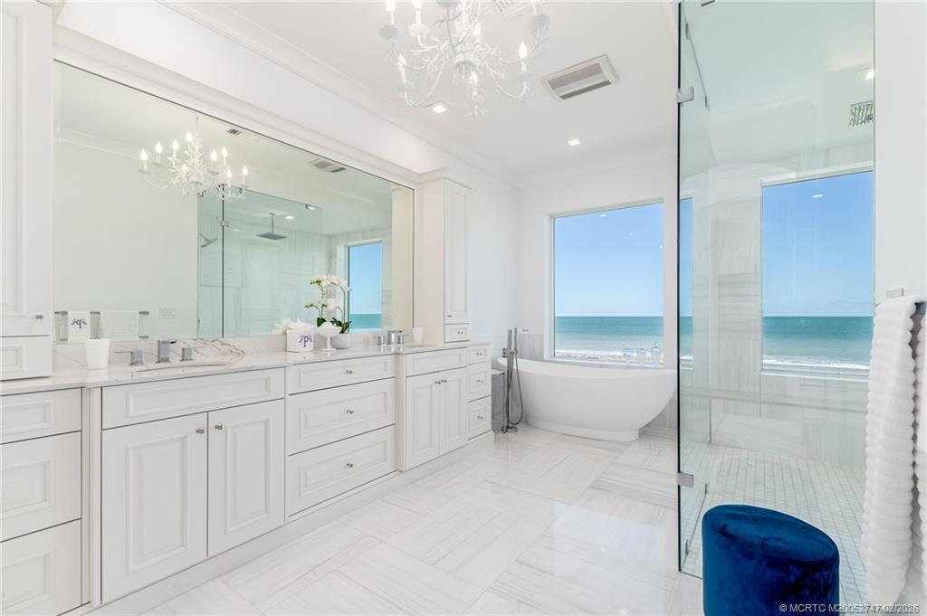 4824 Watersong Way Fort Pierce, FL 34949 - Photo 38 of 65 a spacious bathroom with a double vanity sink a large mirror and a bathtub