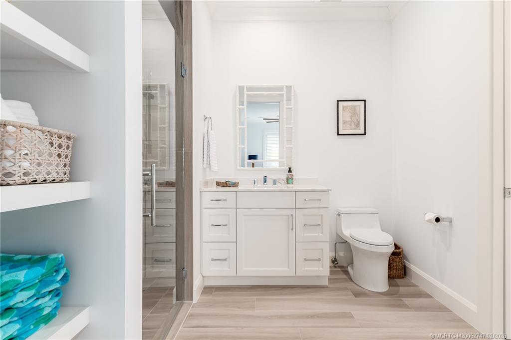 4824 Watersong Way Fort Pierce, FL 34949 - Photo 53 of 65 a bathroom with a sink toilet a mirror and vanity