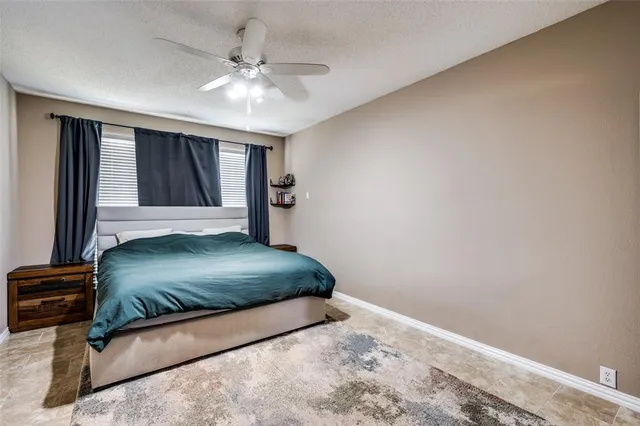a bedroom with a bed and a flat tv screen on dresser