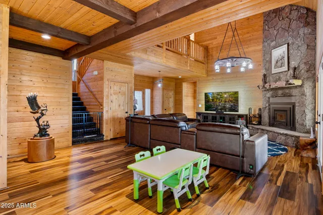 a view of an empty room with wooden floor and windows