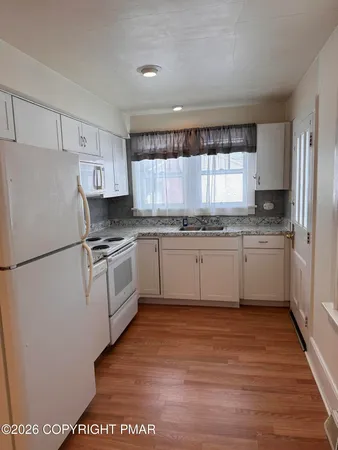 a kitchen with a white cabinets and white appliances