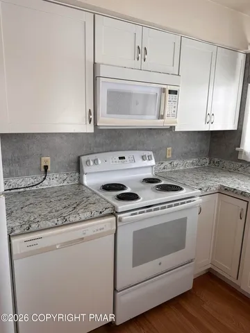 a kitchen with white cabinets and white appliances
