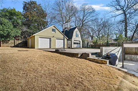 a view of a house with a yard and wooden fence