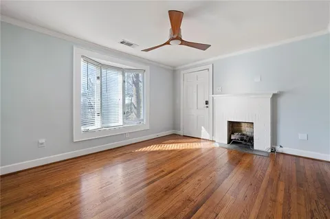a view of empty room with wooden floor and fireplace