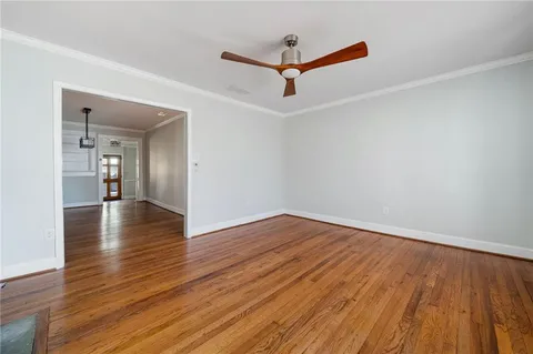 a view of a room with wooden floor and a ceiling fan
