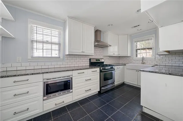 a white kitchen with granite countertop white cabinets and white appliances