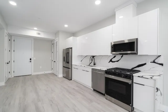 a kitchen with stainless steel appliances a stove a sink and a refrigerator