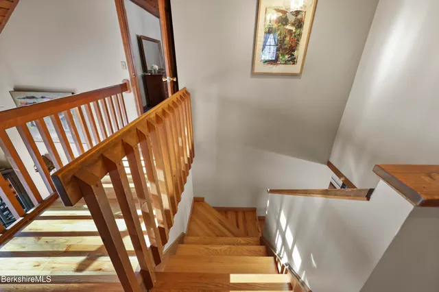 a view of a hallway with wooden floor and stairs